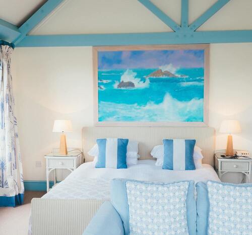 Image de la chambre d'hôtel montrant un lit sous un tableau