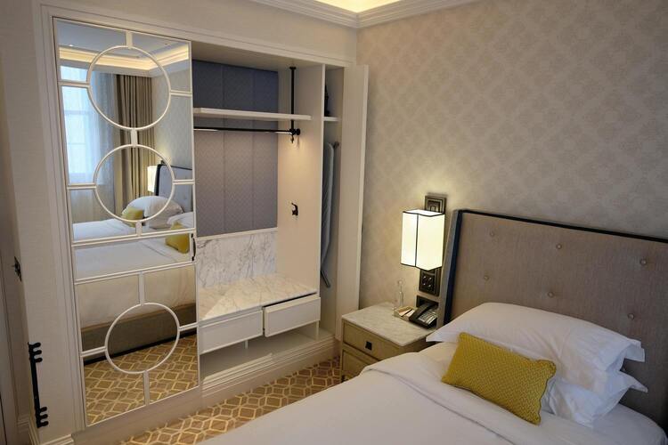 Image de la chambre d'hôtel montrant un lit et une penderie